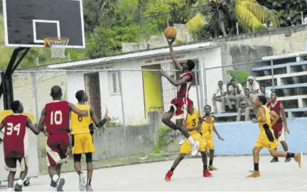  ?? (Photos: Paul Reid) ?? Herbert Morrison’s Akeen Kelly (centre) goes up for a lay-up in their ISSA Western Conference Under-16 semi-final game against York Castle at the Montego Bay Cricket Club on Wednesday.