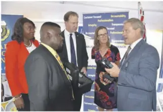  ?? ?? UK Border Force Internatio­nal Western Caribbean Regional Manager, Mike Gorrie, right, shares some informatio­n about the Buster Density Meters to, from left, Deputy CEOS of JCA, Selina Clarke Graham and Marlon Lowe while, Minister Jesse Norman and High Commission­er Judith Slater looks on.