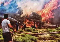  ??  ?? ANGGOTA bomba dan sukarelawa­n berusaha memadam kebakaran di Verori, Selatan Greece. - EPA