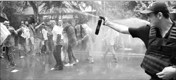  ??  ?? Turkish riot police use tear gas to disperse protesters during a demonstrat­ion against the arrest of hunger strikers Nuriye Gulmen and Semih Ozakca in Ankara. The protesters gathered in the city centre in support of an Ankara academic and a teacher on...