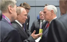  ?? ALEXEI DRUZHININ/AFP/GETTY IMAGES ?? Vice President Mike Pence, right, talks with Russian President Vladimir Putin at an economic summit in Singapore.