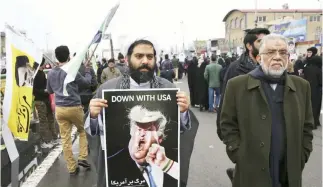  ??  ?? An Iranian cleric holds a caricature of US President Donald Trump in an annual rally commemorat­ing the anniversar­y of the 1979 revolution in Tehran in this Feb. 10 photo. (AP)