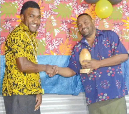  ??  ?? Asereti Vaniqo receives his award from Nayavuloul­ou Methodist Church senior member, Jone Lewa on Friday. Photo: Anasilini Ratuva