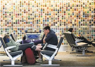  ?? Photos by Jessica Christian / The Chronicle ?? Inge Jennett (left) and Aaron Jennett of Auckland, New Zealand, wait for their flight home at SFO.