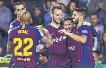  ?? GETTY IMAGES ?? Lionel Messi (second from left) celebrates his hat-trick against Real Betis with his teammates at the Estadio Benito Villamarin in Seville on Sunday.