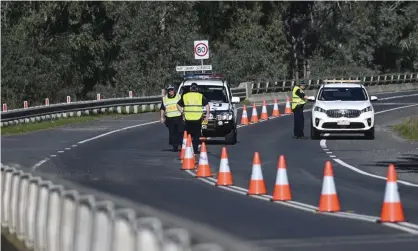  ?? Photograph: Lukas Coch/AAP ?? NSW police patrol the NSW-Victoria border crossing in Howlong near Albury. About 125,000 people from Victoria crossed the border into NSW on Wednesday.