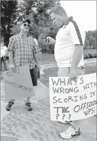  ?? By April L. Brown AP ?? Having their say: Ron Anderson, left, and Chance Blessing wait for a rally to begin in support of Arkansas coach Bobby Petrino.