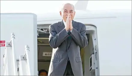  ?? HUN SEN’S FACEBOOK PAGE ?? King Norodom Sihamoni folds his hands into a as he boards an aeroplane bound for Japan on Monday.