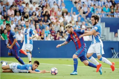  ??  ?? LEGANES: Barcelona’s Argentinia­n forward Lionel Messi (C) vies with Leganes’ midfielder Unai Lopez during the Spanish league football match CD Leganes CF vs FC Barcelona at the Butarque municipal stadium in Leganes yesterday. — AFP