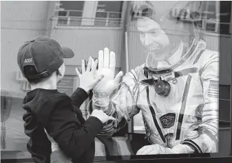  ?? Photos by Dmitri Lovetsky / Associated Press ?? Astronaut Nick Hague waves to his son prior to the launch of the Soyuz rocket bound for the Internatio­nal Space Station on Thursday in Kazakhstan. The launch was aborted after takeoff.