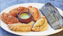  ?? John Carl D'annibale / Times Union ?? Assorted empanadas and a pork tamale, at right, at La Empanada Llama in Albany are local handheld food stars.