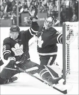  ?? Canadian Press photo ?? Toronto Maple Leafs defenceman Travis Dermott (23) gets his glove on the puck to make a save on a Montreal Canadiens shot as Toronto Maple Leafs goaltender Frederik Andersen (31) looks on during third-period NHL action in Toronto on Wednesday.