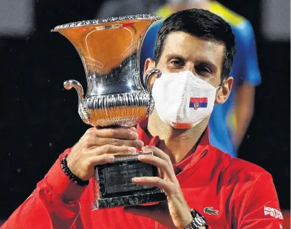  ?? PHOTO: REUTERS ?? When in Rome . . . Serbian world No 1 Novak Djokovic celebrates with the trophy after winning the Italian Open final against Argentine Diego Schwartzma­n in Rome yesterday. Djokovic won 75, 63.