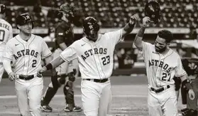  ??  ?? Michael Brantley celebrates with Jose Altuve after his three-run homer in the fifth. The empty stadium was a topic of conversati­on for the Astros’ announcers.