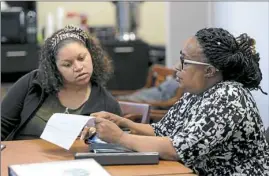  ?? Pam Panchak/Post-Gazette ?? Jamie Johnson with New Sun Rising looks over paperwork with Denise Zellous during a Launch Sto-Rox business incubator program meeting in McKees Rocks.