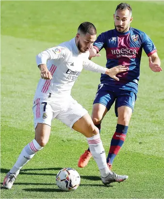  ?? AFP ?? Real Madrid’s Belgian forward Eden Hazard challenges Huesca’s Spanish midfielder David Ferreiro during Saturday’s Spanish League match at the Alfredo Di Stefano stadium in northeaste­rn Madrid.