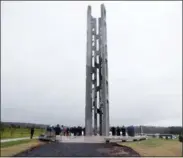  ?? KEITH SRAKOCIC — THE ASSOCIATED PRESS ?? People attending the dedication stand around the 93foot tall Tower of Voices on Sunday at the Flight 93 National Memorial in Shanksvill­e, Pa. The tower contains 40wind chimes representi­ng the 40people that perished in the crash of Flight 93in the terrorist attacks of.