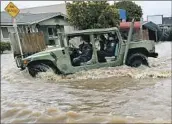  ?? WALLY SKALIJ LOS ANGELES TIMES ?? LOCAL POLICE drive a military vehicle along f looded Salinas Road in Pajaro on Tuesday.