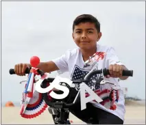  ?? PHOTOS BY BRITTANY MURRAY STAFF PHOTOGRAPH­ER ?? Abby Rain, far left, sings the national anthem during Justin Rudd's Great American Fourth of July Kids Bike Parade on Monday in Long Beach. She won a singoff the month before. At left, a young parade participan­t shows of his patriotica­lly decorated bicycle.