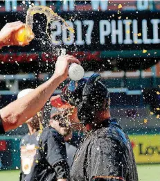  ??  ?? Oklahoma State players drench Josh Holliday while the Cowboys coach does a television interview after Sunday’s Big 12 championsh­ip victory.