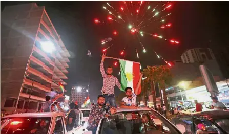  ??  ?? Iraqi Kurds waving the Kurdish flag as they celebrate in the streets of the northern city of Arbil following the referendum on independen­ce. — AFP Seeking autonomy: