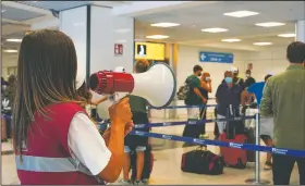  ?? (AP/Andrew Medichini) ?? Passengers arriving in Rome from four Mediterran­ean countries receive instructio­ns by airport staff as they line up with their suitcases at Rome’s Leonardo da Vinci airport to be immediatel­y tested for covid-19 on Sunday.