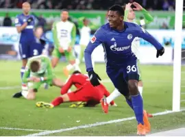  ??  ?? Schalke’s Breel Embolo, right, celebrates an own goal scored by Wolfsburg’s Robin Knoche, rear left, during the match against VfL Wolfsburg Photo: AP