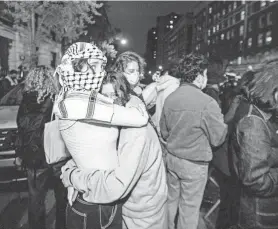  ?? SETH HARRISON/THE JOURNAL NEWS ?? Two people embrace across the street from Columbia University as hundreds of police officers gathered on April 30.