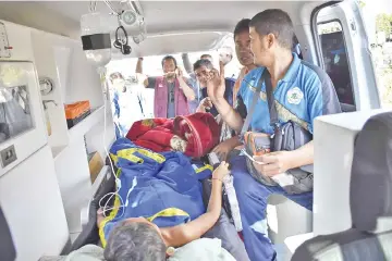  ??  ?? Members of an Indonesian medical team transport an earthquake survivor in an ambulance in Lombok. — AFP photo