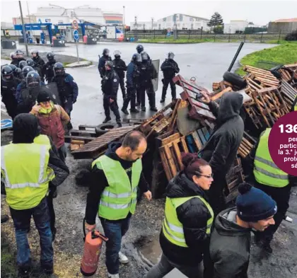  ?? AFP ?? Miembros de los “chalecos amarillos” ponen una barricada cerca de un depósito de combustibl­e, este lunes. El incremento en los impuestos de los hidrocarbu­ros genera la protesta.