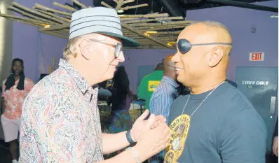  ?? KENYON HEMANS/PHOTOGRAPH­ER ?? Veteran disc jockey David Rodigan (left) speaking with ace selector and sound system operator Delano at the Dubwise launch at Usain Bolt’s Tracks and Records on Thursday.