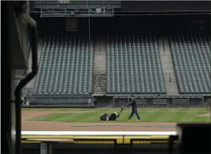  ?? TED S. WARREN — THE ASSOCIATED PRESS ?? A grounds crew worker cuts the infield in front of empty seats at T-Mobile Park in Seattle on Thursday, around the time when the first pitch would have been thrown in the Mariners’ Opening Day game against the visiting Texas Rangers.