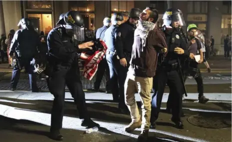  ?? JIM WILSON/THE NEW YORK TIMES ?? Police officers take a protestor into custody at an anti-Donald Trump rally in Oakland, Calif., on Thursday.