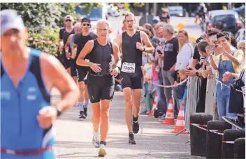  ?? FOTO: ACHIM BLAZY ?? Besonders am Eingang zum Angerbad war die Stimmung bei den Zuschauern des 13. Ratingen Triathlons bestens. Auch das gute Wetter trug seinen Teil dazu bei.