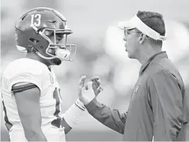  ?? WESLEY HITT/TNS ?? New Hurricanes offensive coordinato­r Dan Enos — seen here speaking to Alabama quarterbac­k Tua Tagovailoa — explained some of his offensive approach Monday and said he wants Miami to be versatile, different and find ways to showcase its playmakers.