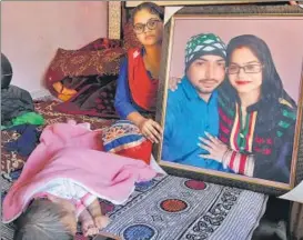  ?? PARDEEP PANDIT / HT PHOTO ?? Navpreet Kaur holds a photo of herself with her husband Dalbir Singh who was killed in the Joda Phatak train accident. Thirtyyear­old Dalbir, who played the role of Ravana in the Ramlila at the Dussehra function, was killed while trying to save lives on Friday.