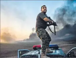  ?? AFP/REUTERS ?? A member of the Iraqi government forces takes position on top of a vehicle on the outskirts of Qayyarah area near Mosul during an operation against Islamic State; (top right) a displaced woman who fled from Mosul holds her baby at a camp in the...