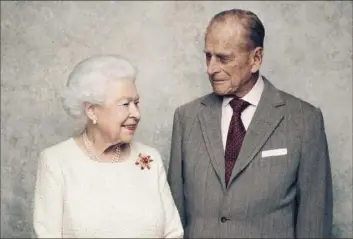  ?? Matt Holyoak/Camera Press via AP ?? In November 2017, Britain’s Queen Elizabeth and Prince Philip pose for a photograph in the White Drawing Room at Windsor Castle, England.