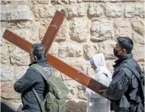  ?? Photo / AP ?? Christians carry a cross to the Church of the Holy Sepulchre in Jerusalem.