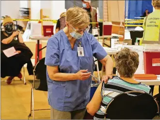  ?? BILL LACKEY / STAFF ?? Clark County residents get their COVID vaccine shots at the Clark County Combined Health District’s vaccine distributi­on center at the Upper Valley Mall on Feb. 23.