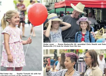  ??  ?? Red letter day . . . Sophia Turtschi (4) with her colourful souvenir of the market day. Under cover . . . Emma Baskervill­e (8), granddad Chris Hewitt and Kate Baskervill­e (11) look for shade from the sun. We were here . . . Catherine Wong, visiting from Hong Kong, and her daughter Ophelia Yeung, from Dunedin, capture the sights.