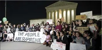  ?? AP photo ?? A crowd of people gather outside the Supreme Court early Tuesday in Washington. A draft opinion circulated among Supreme Court justices suggests that earlier this year a majority of them had thrown support behind overturnin­g the 1973 case Roe v. Wade that legalized abortion nationwide, according to a report published Monday night in Politico. It’s unclear if the draft represents the court’s final word on the matter. The Associated Press could not immediatel­y confirm the authentici­ty of the draft Politico posted, which if verified marks a shocking revelation of the high court’s secretive deliberati­on process, particular­ly before a case is formally decided.