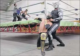  ?? Gary Coronado Los Angeles Times ?? GRAN TORO chokes Azteca Negro with a chain as the referee tries to separate other wrestlers in an event closed to the public but broadcast online last month.