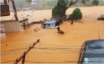  ??  ?? Cars submerged in muddy water in streets in Regent.