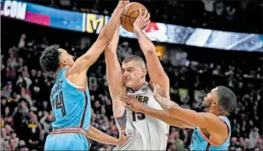  ?? ?? Los jugadores de los Suns Landry Shamet y Mikal Bridges tratan de parar a Nikola Jokic, pívot de Denver.