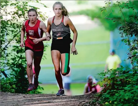  ?? SARAH GORDON/THE DAY ?? Montville’s Mady Whittaker, right, fights NFA’s Catie Shannon for the lead during Thursday’s meet at Montville High School. Shannon, a freshman, came back to beat Whittaker for individual honors and helped NFA sweept the tri-meet with wins over the...