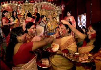  ?? — PRITAM BANDYOPADH­YAY ?? Women apply vermilion during sindoor khela ceremony, which marks the end of Durga Puja celebratio­ns, at Aram Bagh puja pandal in New Delhi on Friday.