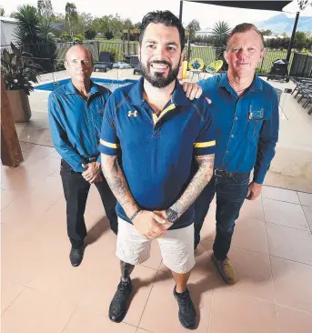  ?? Picture: ALIX SWEENEY ?? GREAT WORK: Michael Rach and Wayne Rossow ( back) from Micra Constructi­ons are helping injured veteran Paul Warren ( centre) by installing anti- slip tile treatment around his pool.