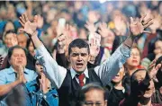  ?? [AP PHOTO] ?? A man prays Sunday during an evangelica­l service at Manantial Church in Bogota, Colombia. In Latin America the flight from the Catholic Church is spreading, where 20 percent identify as non-Catholic Christians.