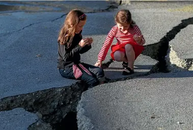  ?? IAIN MCGREGOR/ STUFF ?? Sisters play in the cracks of a damaged road in Christchur­ch in 2011.